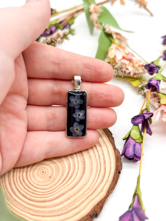 Silver plated necklace with black pendant and forget me not flowers