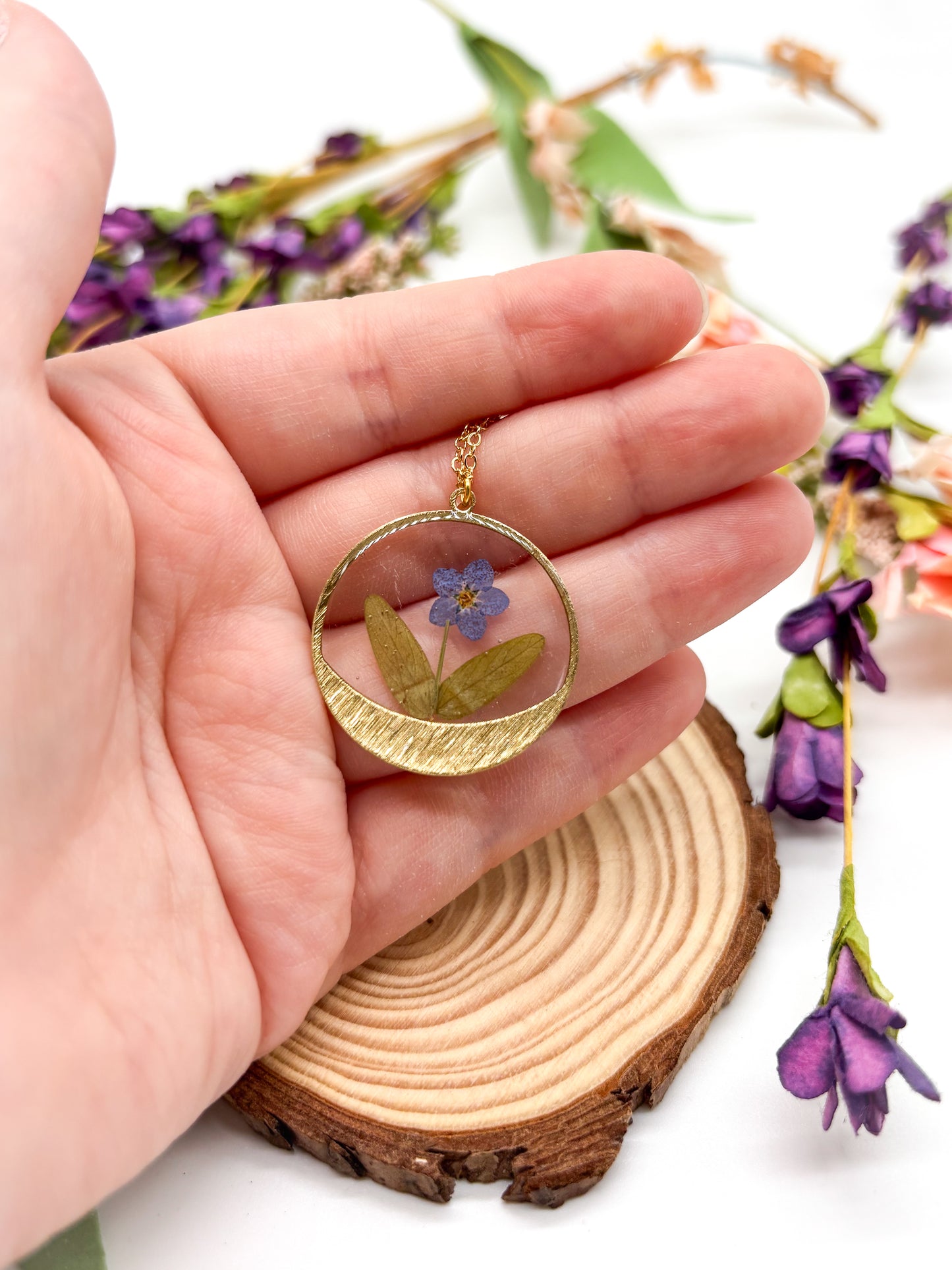 round pendant with forget me not flower