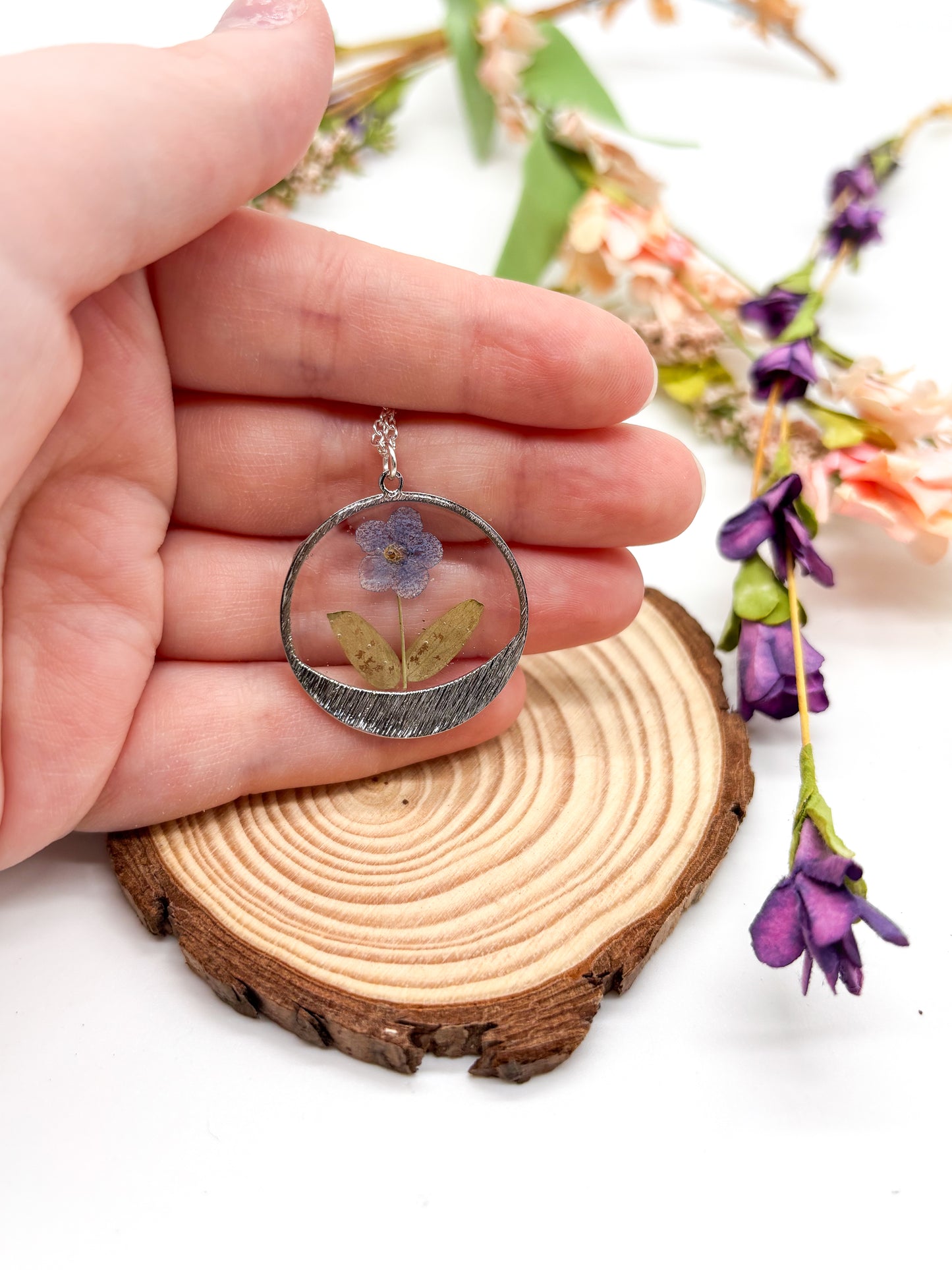round pendant with forget me not flower